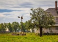 Typical North American Country Farm House in overcast day. Farm yard with the house and old windmill Royalty Free Stock Photo