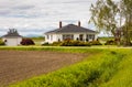 Typical North American Country Farm House in overcast day. Farm yard with the plowed field infront Royalty Free Stock Photo