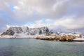 Typical Norwegian landscape. Beautiful view of scenic Lofoten Islands winter scenery with traditional yellow fisherman Rorbuer cab Royalty Free Stock Photo