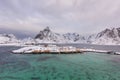 Typical Norwegian landscape. Beautiful view of scenic Lofoten Islands winter scenery with traditional yellow fisherman Rorbuer cab