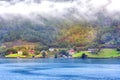 Norwegian old wooden houses and fog in summer, Norway Royalty Free Stock Photo