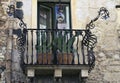 Typical old residential house with balcony decorated by cacti in flower pots. Authentic decoration of balconies in Taormina. Royalty Free Stock Photo