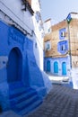 Narrow street with some houses with old doors, all painted blue in the medina of Chefchaouen, Morocco Royalty Free Stock Photo