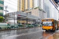 Typical orange bus in heavy rain in Bangkok Thailand