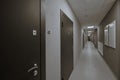 Ypical ordinary corridor of a residential building, painted in bright colors, metal unnamed apartment doors, rich shades