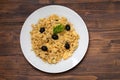 Typical portuguese dish bacalhau a bras on white plate on brown background