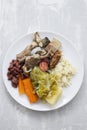 Typical portuguese dish boiled meat, smoked sausages, vegetables and rice on white plate Royalty Free Stock Photo