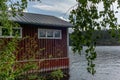 A typical red boat house on the shore of the Saimaa lake in Fin