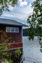 A typical red boat house on the shore of the Saimaa lake in Fin