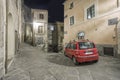 Typical red car in a narrow street in an Italian old town at night Royalty Free Stock Photo