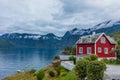 Wooden red cottage. Stone snowy mountains. Norway. Royalty Free Stock Photo