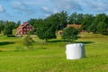 Typical red wooden houses in countryside by the sea in nature of southern Sweden on a beautiful sunny summer day. White Royalty Free Stock Photo