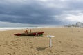 A typical red wooden rescue boat on the beach of Rimini, Italy, during a winter storm Royalty Free Stock Photo