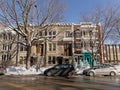 Typical Montreal rowhouses with staircases along a street with heaps of snow on the side