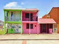 Typical rural Caribbean style houses with pink and green colored walls and headliner, shuttered windows and doors. Tropical
