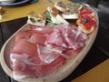 Typical rustic tuscan appetizer with crostini, prosciutto, brawn, salami, cheese on a wooden tray . Italian starter