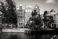 Amsterdam, Holland, the Netherlands - July 6 2020: 6 typical canal houses at a canal with moving trees and a kissing couple in