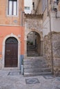 typical small natural stone staircase and wall with semicircular arch in the old town of taormina Royalty Free Stock Photo