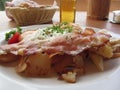 Typical South Tyrolean dish with speck, fried eggs, potatoes and chive Royalty Free Stock Photo