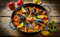 Typical spanish seafood paella in traditional pan. Vegetable paella with seafood on a wooden background Royalty Free Stock Photo