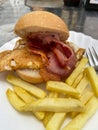 Typical Spanish tapa food known as mohicano, consisting of grilled egg, bacon inside a bread roll and accompanied by french fries Royalty Free Stock Photo