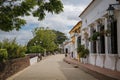 River promenade with historic white buildings, colorful pillars and trees trees of Santa Cruz de Mompox, Colombia, World Heritage