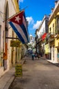 Typical street in Old Havana with a big cuban flag Royalty Free Stock Photo