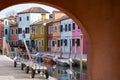 Typical street scene showing brighly painted houses besides canal on the island of Burano, Venice.