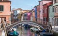 Typical street scene showing brighly painted houses and bridge over canal on the island of Burano, Venice. Royalty Free Stock Photo