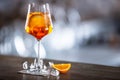 Typical summer sekt drink aperol spritz served in wine glass with aperol, prosecco, soda and a slice of orange