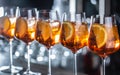 Typical summer sekt drink aperol spritz served in wine glasses with aperol, prosecco, soda and a slice of orange