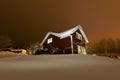 Typical Swedish red wooden house, winter garden with fruit trees, huge snowdrifts, the sky is totally closed by thick clouds. Much