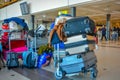 A typical travel scene: luggage cart full of baggages and bags in the middle of the airport terminal Royalty Free Stock Photo