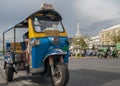 A typical tuk tuk taxi in the historic center of Bangkok, Thailand, with one of the most famous temples in the background Royalty Free Stock Photo