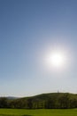 Typical Tuscany Val d`Orcia landscape, with an isolated cypress tree on a hill in the middle of green grass and sun Royalty Free Stock Photo