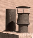 Typical two old metallic pipes on a tiled roof