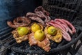 Typical Uruguayan and Argentine Asado Cooked on fire. Entrana and Vacio meat cuts. Accompanied with Chorizo Royalty Free Stock Photo