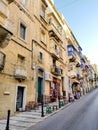 Typical Valletta street with colorful balcony on facades climbing up