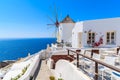 Typical white windmill on street of Oia village with blue sea in background, Santorini island, Greece Royalty Free Stock Photo