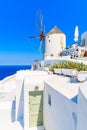 Typical white windmill on street of Oia village, Santorini island, Greece Royalty Free Stock Photo