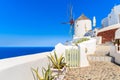 Typical white windmill on street of Oia village, Santorini island, Greece Royalty Free Stock Photo
