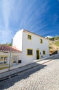 Typical whitewashed portuguese house in the street with steep slope. Salema village, Discrict Faro, Algarve, Southern Portugal Royalty Free Stock Photo