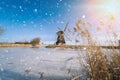 Typical winter dutch landscape with windmill. frozen canal in netherlands. Traditional winter holland scene. winter snow Royalty Free Stock Photo