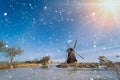 Typical winter dutch landscape with windmill. frozen canal in netherlands. Traditional winter holland scene. winter snow Royalty Free Stock Photo