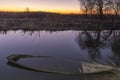 Typical wooden boat submerged in water in the wet area called Padule di Fucecchio, Tuscany, Italy, at sunset