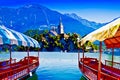 Typical wooden boats, in slovenian called Pletna, in Bled Lake, the most famous lake in Slovenia with the island of the church Royalty Free Stock Photo