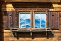 Typical wooden house window in the mountains with mirrored mount