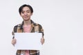 A typical young asian man holding a blank white signage Isolated on a white background. Copyspace on the right Royalty Free Stock Photo