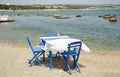Typically Greek blue restaurant table and chairs beside the sea Royalty Free Stock Photo