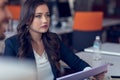 Typing business message. Confident young woman in smart casual wear holding smart phone and looking at it with smile Royalty Free Stock Photo